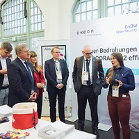 Eine Frau erklärt auf der protekt 2024 einer Gruppe von Personen einen Sachverhalt an einem Messestand mit Bannern mehrerer Firmen, darunter epeon und EnBW. Eine Frau erklärt auf der protekt 2024 einer Gruppe von Personen einen Sachverhalt an einem Messestand mit Bannern mehrerer Firmen, darunter epeon und EnBW.