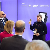 Ein Mann steht während der protekt 2024 vor einer Gruppe von Personen und hält eineKarte hoch; im Hintergrund ist eine lilafarbene Wand zu sehen Ein Mann steht während der protekt 2024 vor einer Gruppe von Personen und hält eineKarte hoch; im Hintergrund ist eine lilafarbene Wand zu sehen