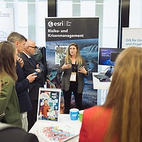 Eine Frau erklärt auf der protekt 2024 einer Gruppe von Personen einen Sachverhalt an einem Messestand der Firma Esri zum Thema Risiko- und Krisenmanagement. Eine Frau erklärt auf der protekt 2024 einer Gruppe von Personen einen Sachverhalt an einem Messestand der Firma Esri zum Thema Risiko- und Krisenmanagement.